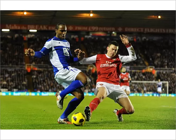 Intense Rivalry: Koscielny vs. Jerome's Battle for Ball Possession (Birmingham City vs. Arsenal, Premier League, St. Andrew's, 01-01-2011)