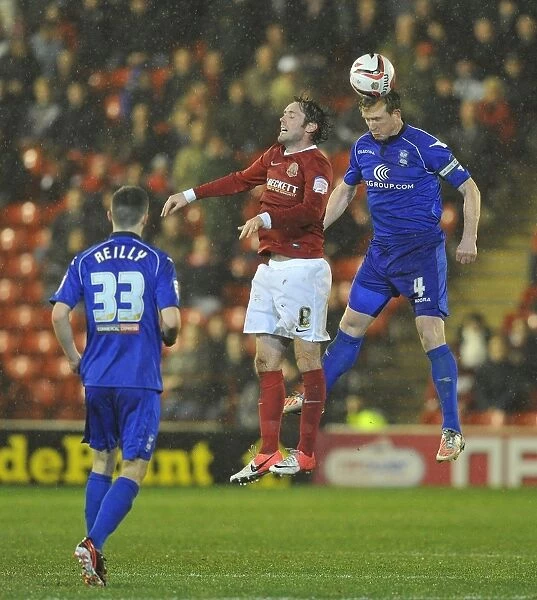 Birmingham City's Stephen Caldwell Soars Over Barnsley's James O'Brien in Npower Championship Showdown at Oakwell