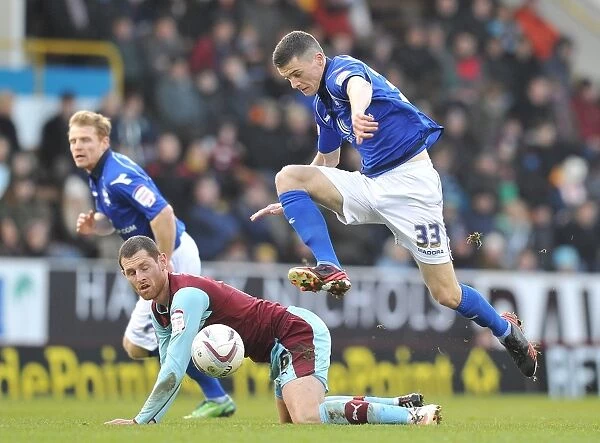 Leaping Past Obstacles: Callum Reilly Soars Over Chris McCann in Birmingham City's Npower Championship Battle (January 26, 2013 - Turf Moor)