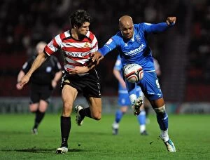 30-03-2012 v Doncaster Rovers, Keepmoat Stadium Collection: Intense Rivalry: Marlon King vs George Friend Battle for Ball in Npower Championship